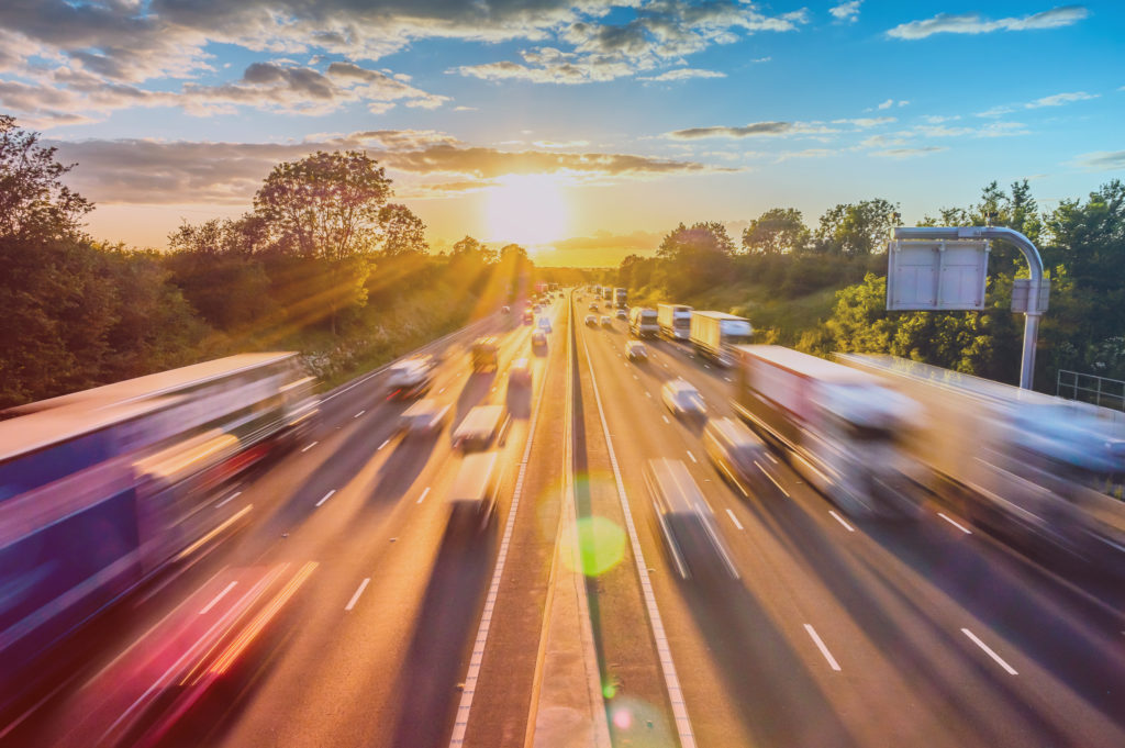 heavy traffic moving at speed on UK motorway in England at sunset